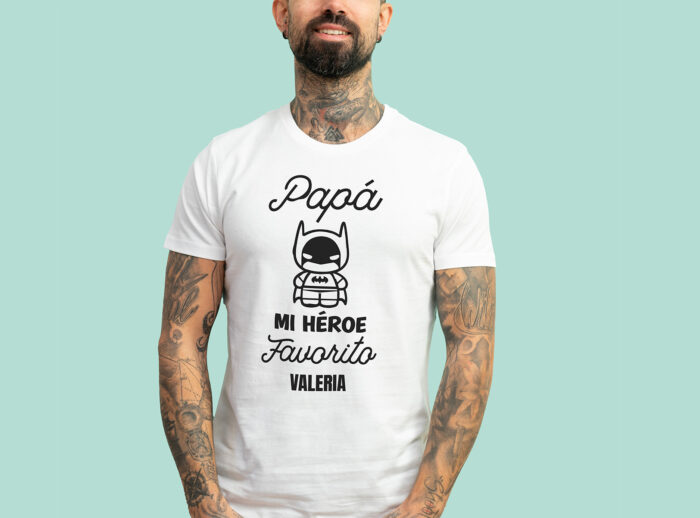 Camiseta blanca con la frase 'Papá, mi héroe favorito', adornada con un dibujo de un superhéroe y personalizada con el nombre que elijas.