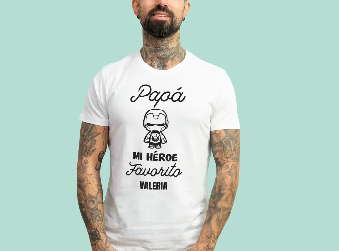Camiseta blanca con la frase 'Papá, mi héroe favorito', adornada con un dibujo de un superhéroe y personalizada con el nombre que elijas.