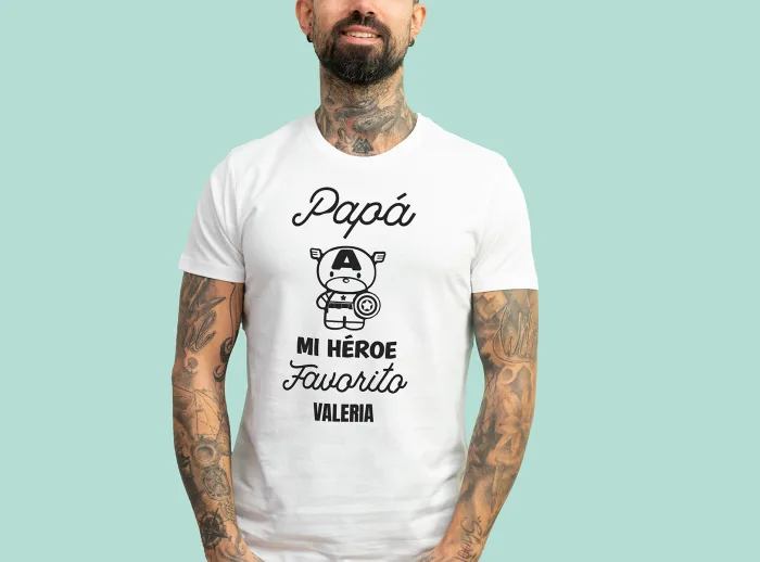 Camiseta blanca con la frase 'Papá, mi héroe favorito', adornada con un dibujo de un superhéroe y personalizada con el nombre que elijas.