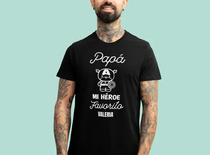 Camiseta negra con la frase 'Papá, mi héroe favorito', adornada con un dibujo de un superhéroe y personalizada con el nombre que elijas.