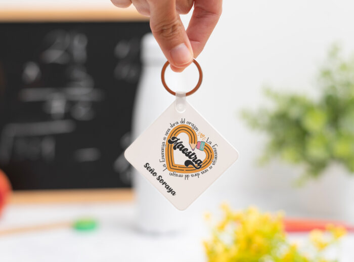 Llavero cuadrado personalizado con el texto ‘Maestra' y ‘La enseñanza es una obra del corazón', nombre de la profesora, curso y nombres de los niños en el reverso