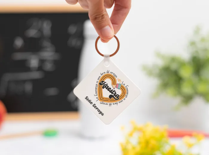 Llavero cuadrado personalizado con el texto ‘Maestra' y ‘La enseñanza es una obra del corazón', nombre de la profesora, curso y nombres de los niños en el reverso