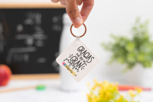 Llavero cuadrado personalizado con mensaje 'Gracias por ser un gran profesor', nombre del profesor, curso y nombres de los niños en el reverso