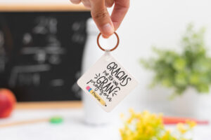 Llavero cuadrado personalizado con mensaje 'Gracias por ser una gran profesora', nombre de la profesora, curso y nombres de los niños en el reverso
