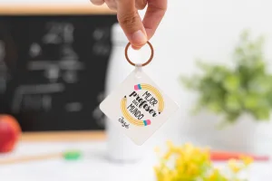 Llavero cuadrado personalizado con mensaje 'Mejor profesor del mundo', nombre del profesor, curso y nombres de los niños en el reverso