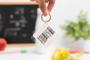 Llavero cuadrado personalizado con mensaje ‘El profesor que ama enseñar hace que sus alumnos amen aprender', nombre del profesor, curso y nombres de los niños en el reverso
