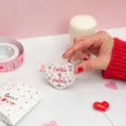 Llavero de enamorados con forma de corazón. Personalizado con nombres y fecha. Fondo con diseño con temática de enamorados de fondo