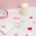 Llavero de enamorados con forma de corazón. Personalizado con nombres y fecha. Fondo con diseño con temática de enamorados de fondo