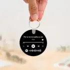 Llavero redondo personalizado con código Spotify, título de la canción y nombre del artista en un lado, y una imagen personalizada en el otro.