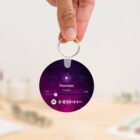 Llavero redondo personalizado con código Spotify, título de la canción y nombre del artista en un lado, y una imagen personalizada en el otro.