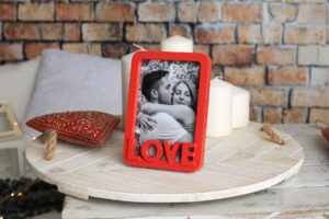 Marco de temática enamorados en rojo para foto 10x15 cm con la palabra 'Love' en relieve