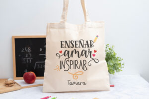 Tote bag personalizada con mensaje 'Enseñar, amar, inspirar', nombre de la profesora, curso y nombres de los niños en el reverso