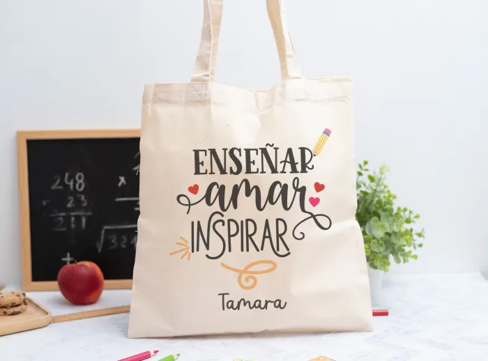 Tote bag personalizada con mensaje 'Enseñar, amar, inspirar', nombre de la profesora, curso y nombres de los niños en el reverso