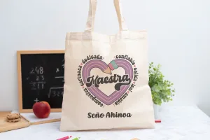 Tote bag personalizada con el texto Maestra y los adjetivos ‘Comprensiva, cariñosa, dedicada, confiable, cálida, leal y amable', nombre de la profesora, curso y nombres de los niños en el reverso