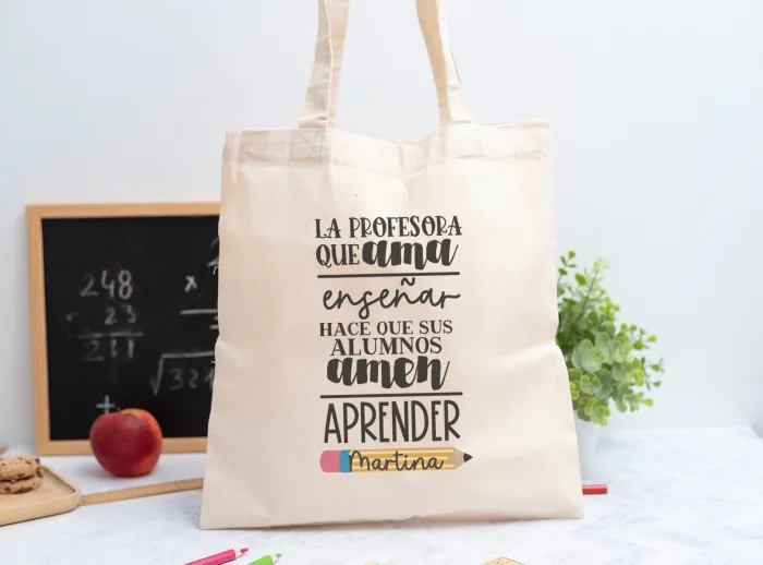 Tote bag personalizada con mensaje ‘La profesora que ama enseñar hace que sus alumnos amen aprender', nombre de la profesora, curso y nombres de los niños en el reverso